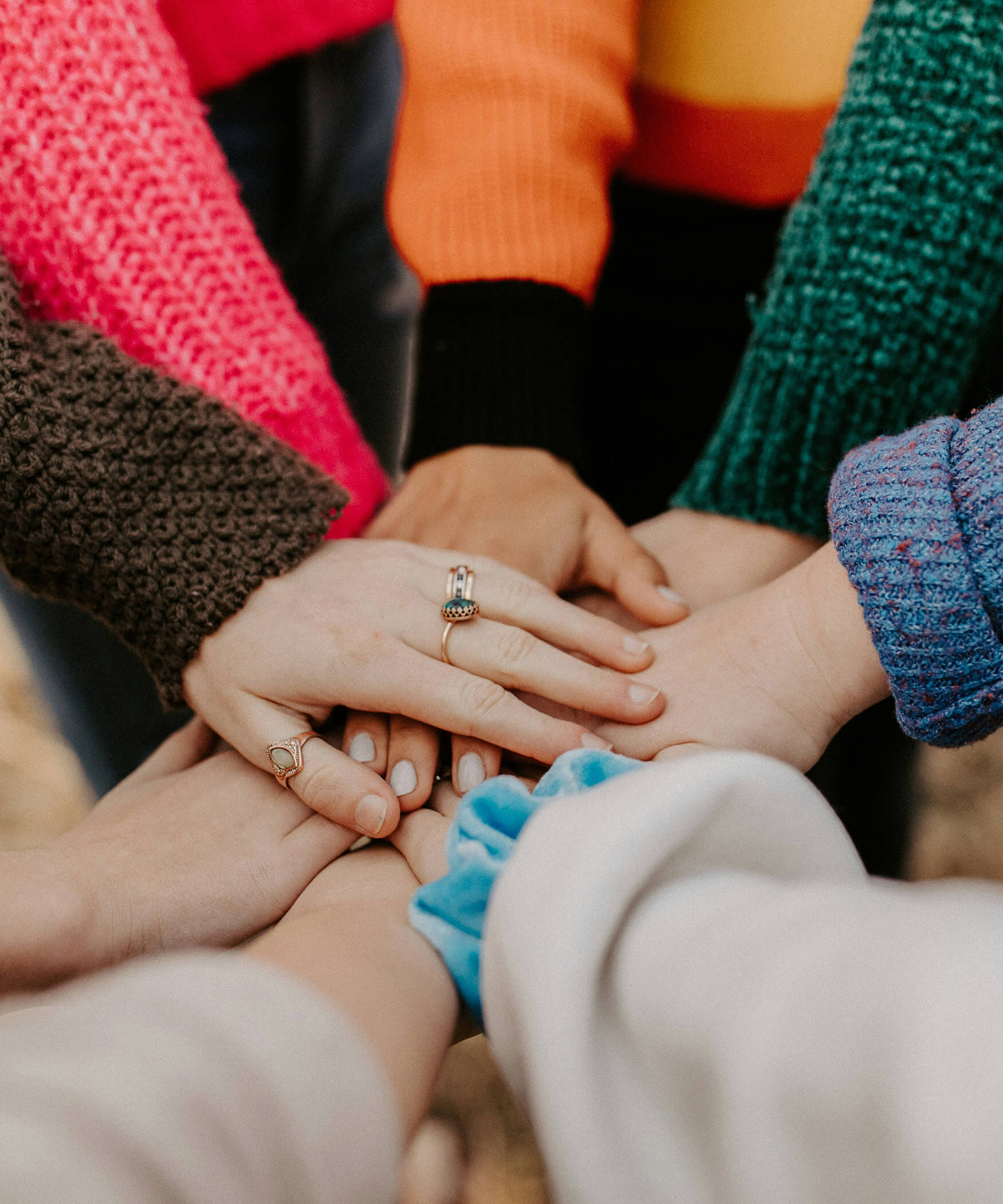 Several hands stacked on top of each other