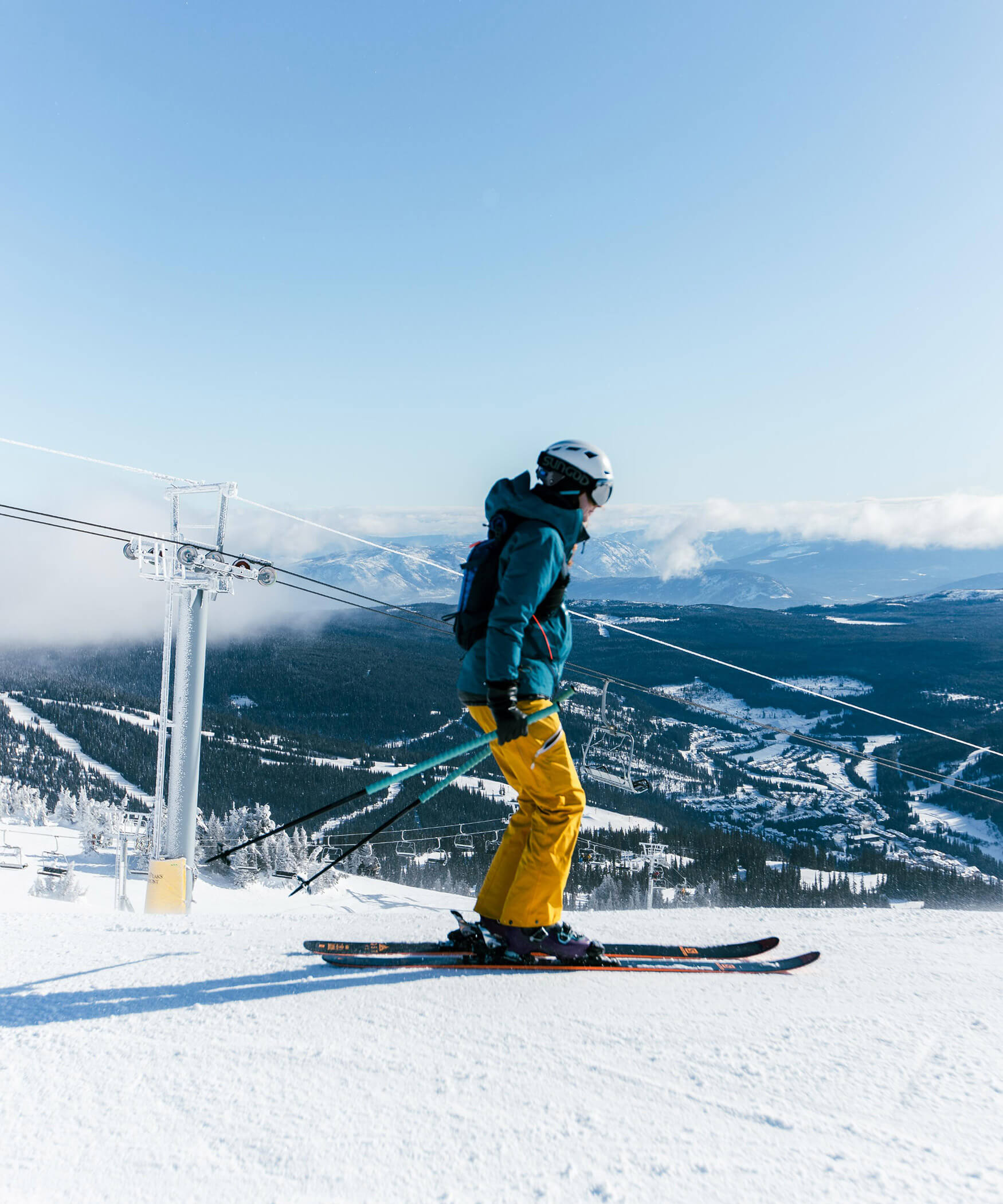 A skier stands on the piste and looks down into the valley